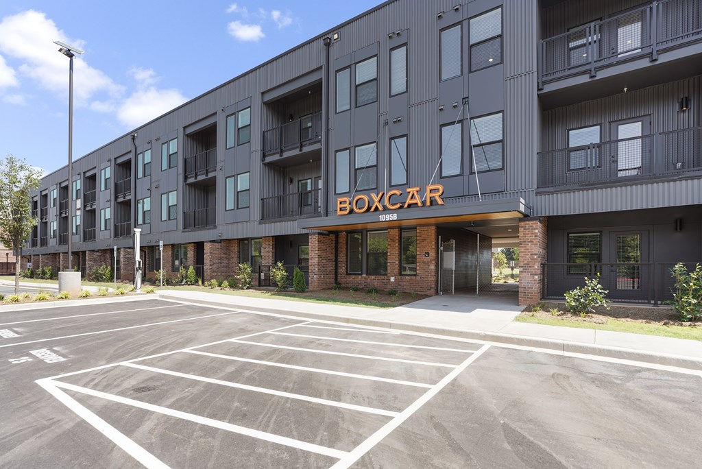 A parking lot in front of a building with the word BOXCAR on it.