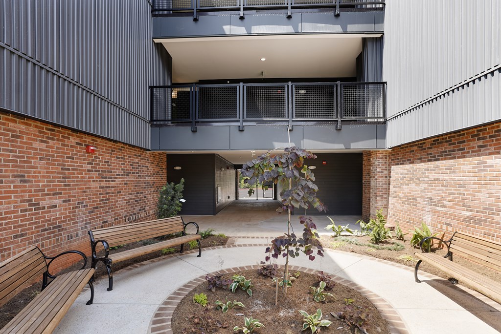 A courtyard with a brick wall and a bench.