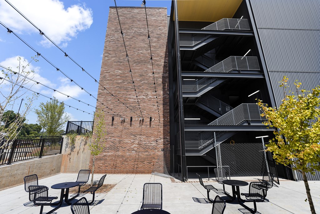 A modern building with a black exterior and a brick wall with the word "PITCH" written on it.