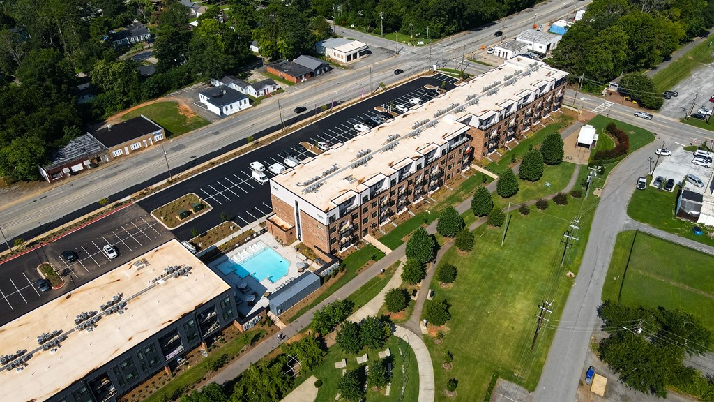 An aerial view of a parking lot, a building, and a road.