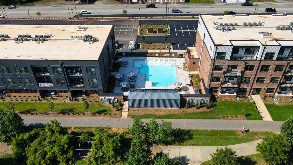 An aerial view of a building with a pool in the foreground.