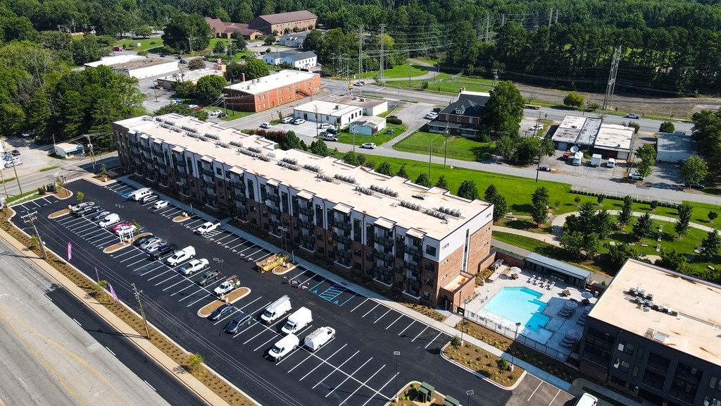 A parking lot with cars and a building in the background.