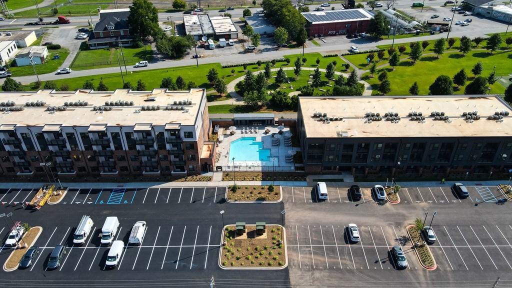 A parking lot with cars and a swimming pool in the background.