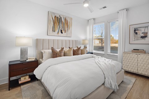 A bedroom with a large bed and a painting on the wall.