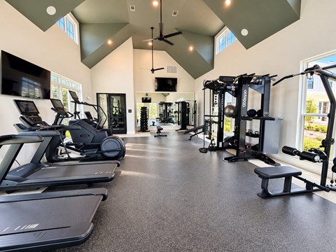 A spacious gym with treadmills, elliptical machines, and weightlifting equipment.
