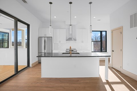 A modern kitchen with a large island and stainless steel appliances.