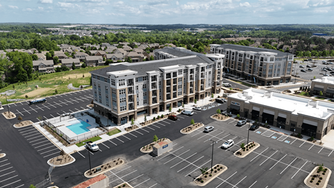 A large building with a pool in the parking lot.