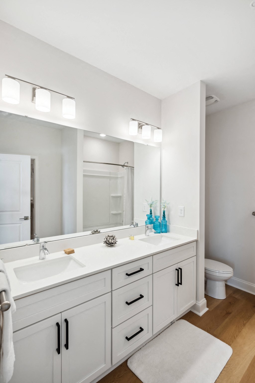 a white bathroom with a large mirror and two sinks
