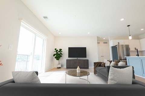 A modern living room with a grey sofa and a flat screen TV.