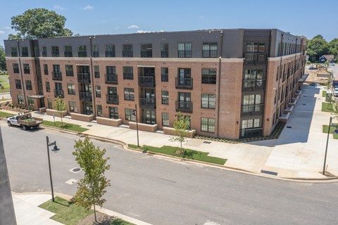 a large brick building with a lot of windows and a street in front of it