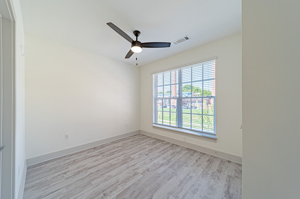a bedroom with hardwood floors and a ceiling fan