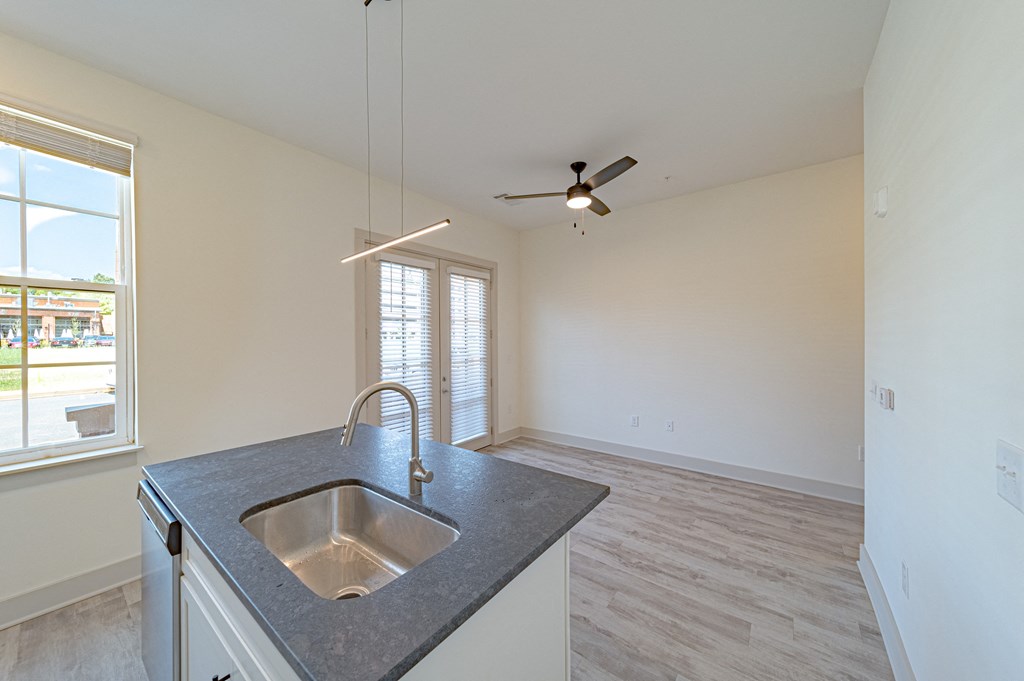 a kitchen with a sink and a ceiling fan