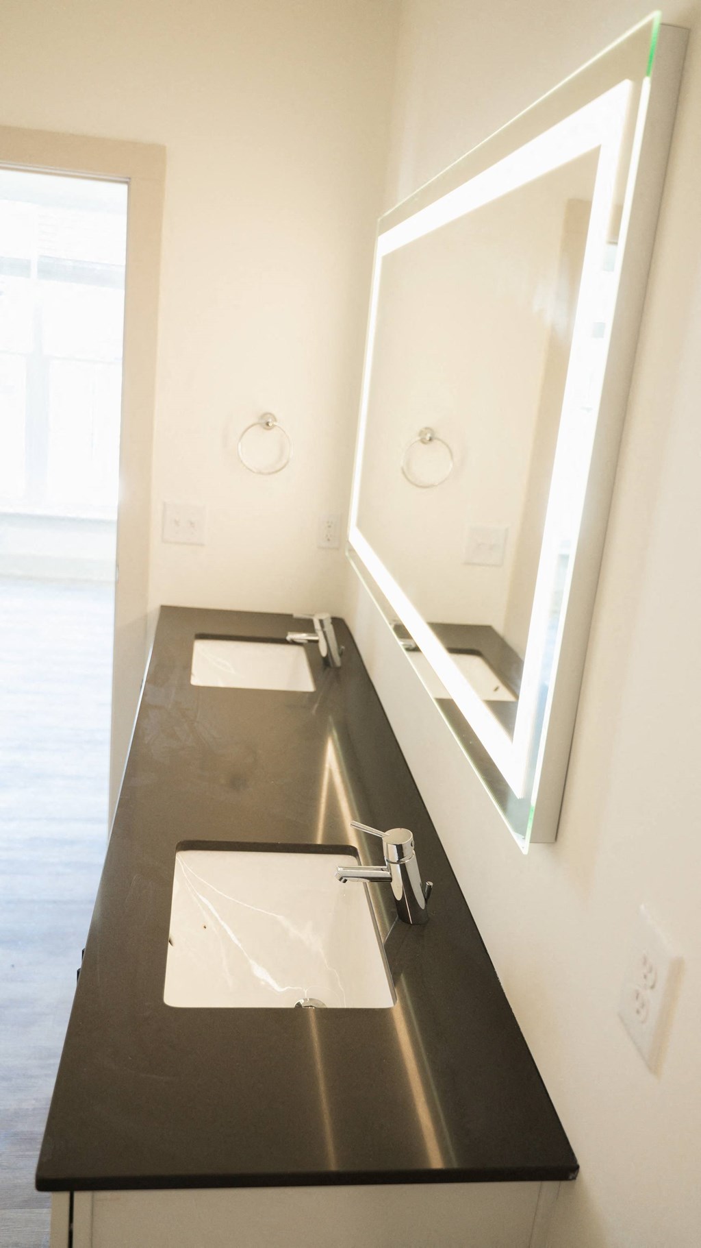 a bathroom with white walls and black countertops
