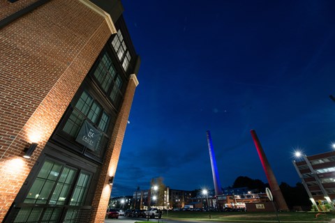 a view of a building at night with the tower in the background