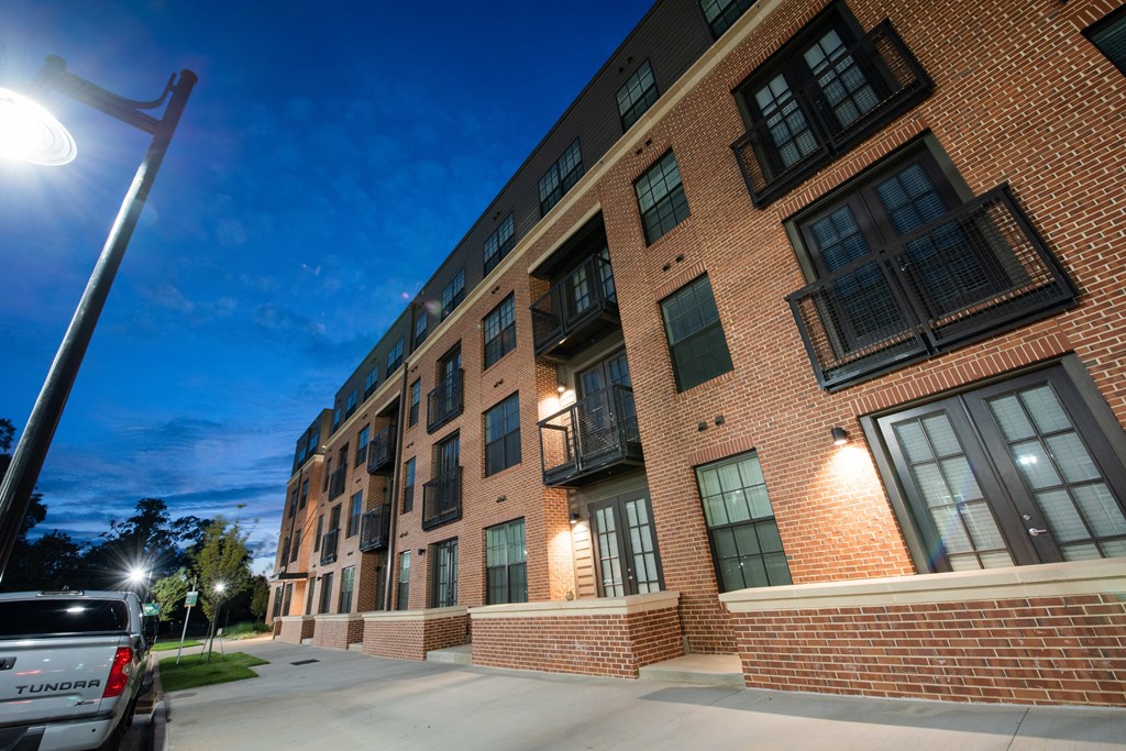 a large brick apartment building at night with a street light
