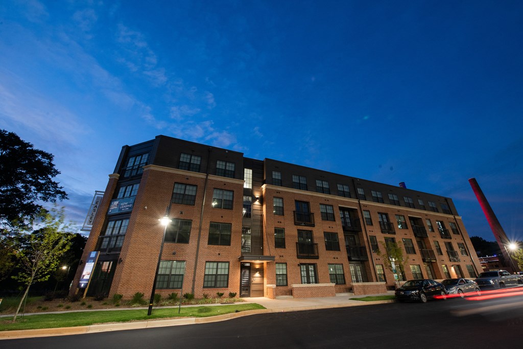 a large brick building at night with a blue sky