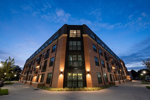 a large brick building at night with the windows lit up