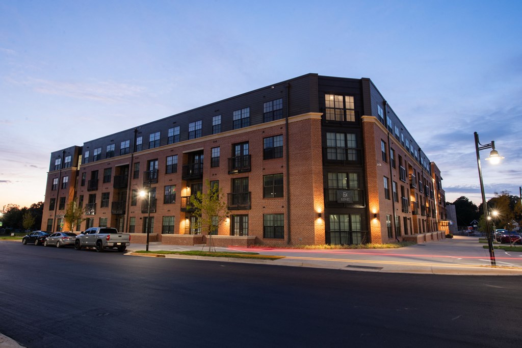 a large brick building on a street corner at dusk