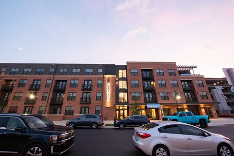 a city street with cars parked in front of a building