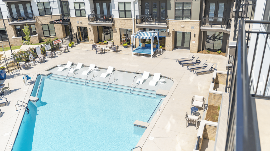 an aerial view of a pool with lounge chairs and umbrellas in front of a building at The Fitzgerald, Spartanburg, SC, 29302