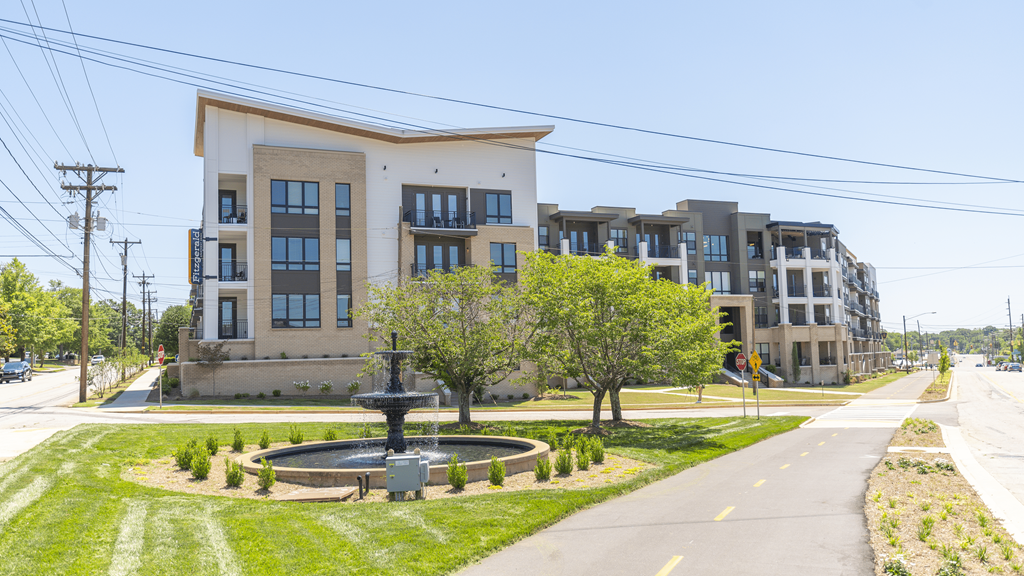 a fountain sits in the middle of a grassy area in front of a large apartment building at The Fitzgerald, Spartanburg, South Carolina