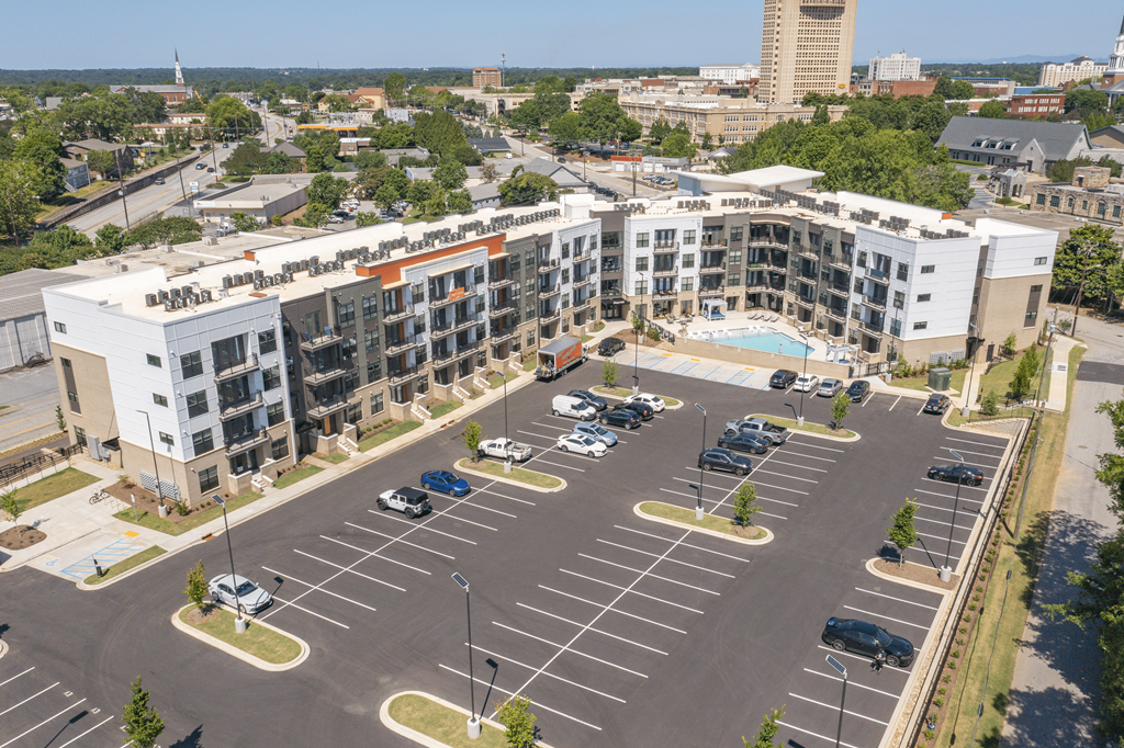 an aerial view of a parking lot with several apartment buildings in the background at The Fitzgerald, South Carolina, 29302