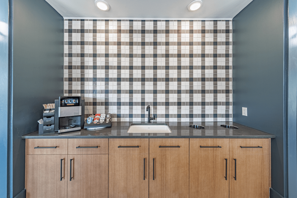 a kitchen with a black and white checkered wall at The Fitzgerald, Spartanburg, 29302
