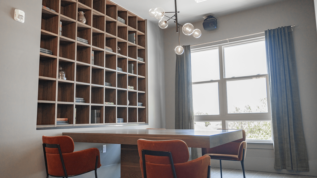 a room with a table and chairs in front of a bookshelf at The Fitzgerald, Spartanburg, SC, 29302