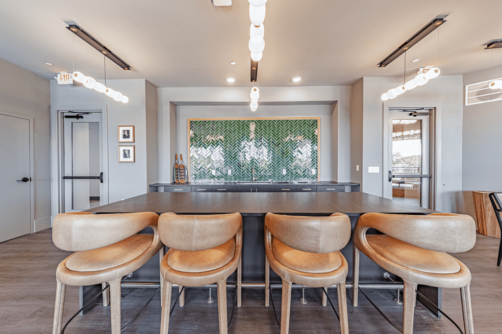 a kitchen with a long island with a bunch of chairs in front of it at The Fitzgerald, Spartanburg, SC