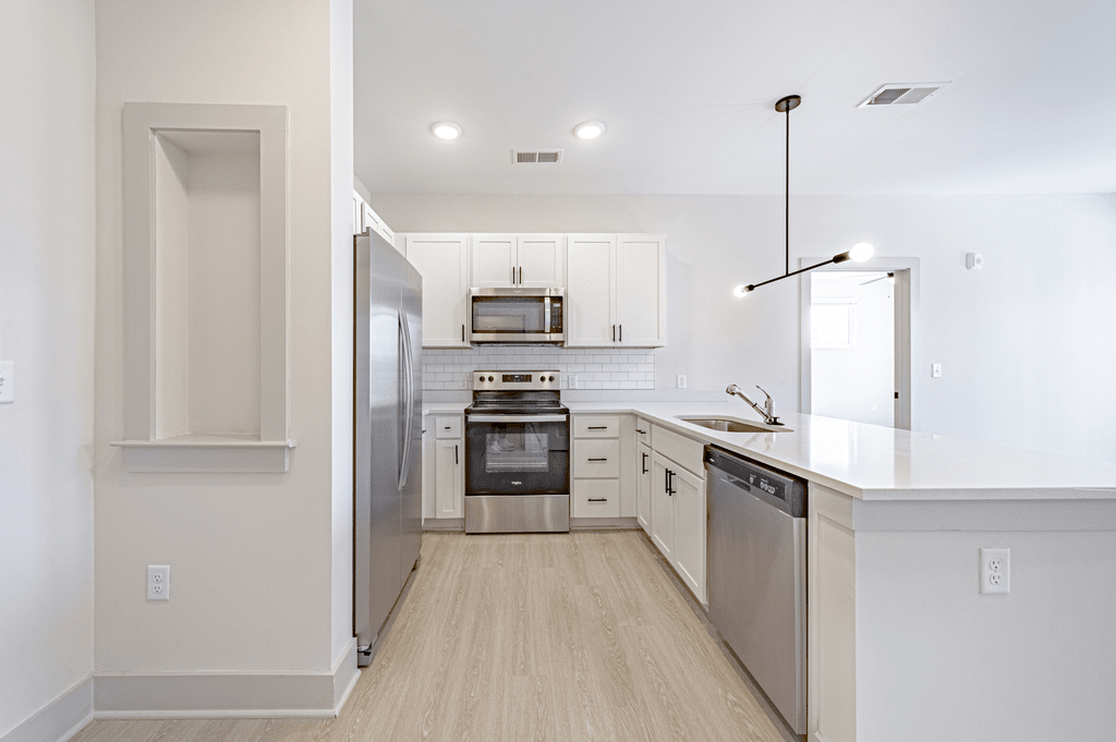a kitchen with white cabinets and stainless steel appliances at The Fitzgerald, Spartanburg, 29302