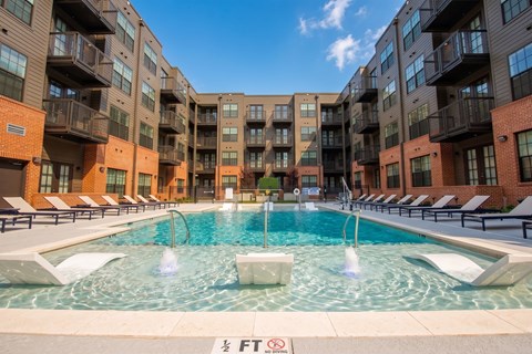 A large swimming pool in front of apartment buildings.