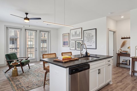 A kitchen with a black countertop and white cabinets.