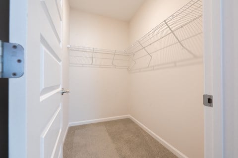 a spacious closet in a home with white walls and a white door