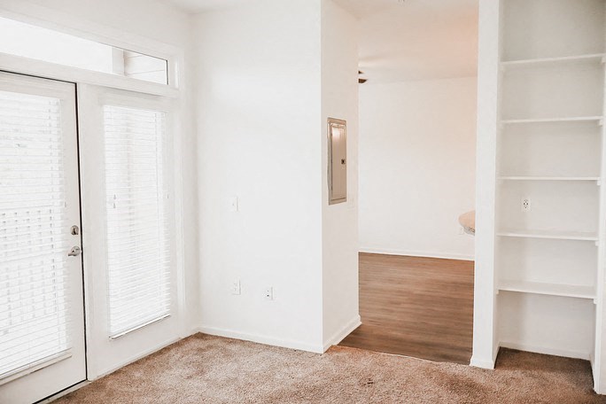 a bedroom with white walls and a closet with white doors