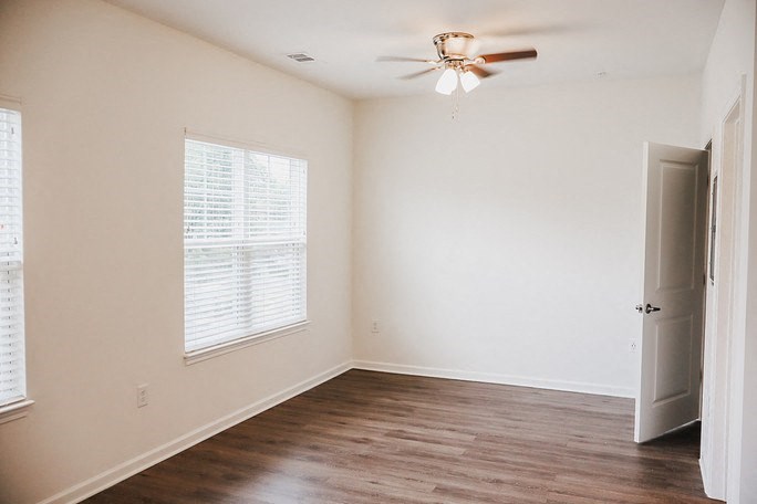 A room with a ceiling fan and a door.