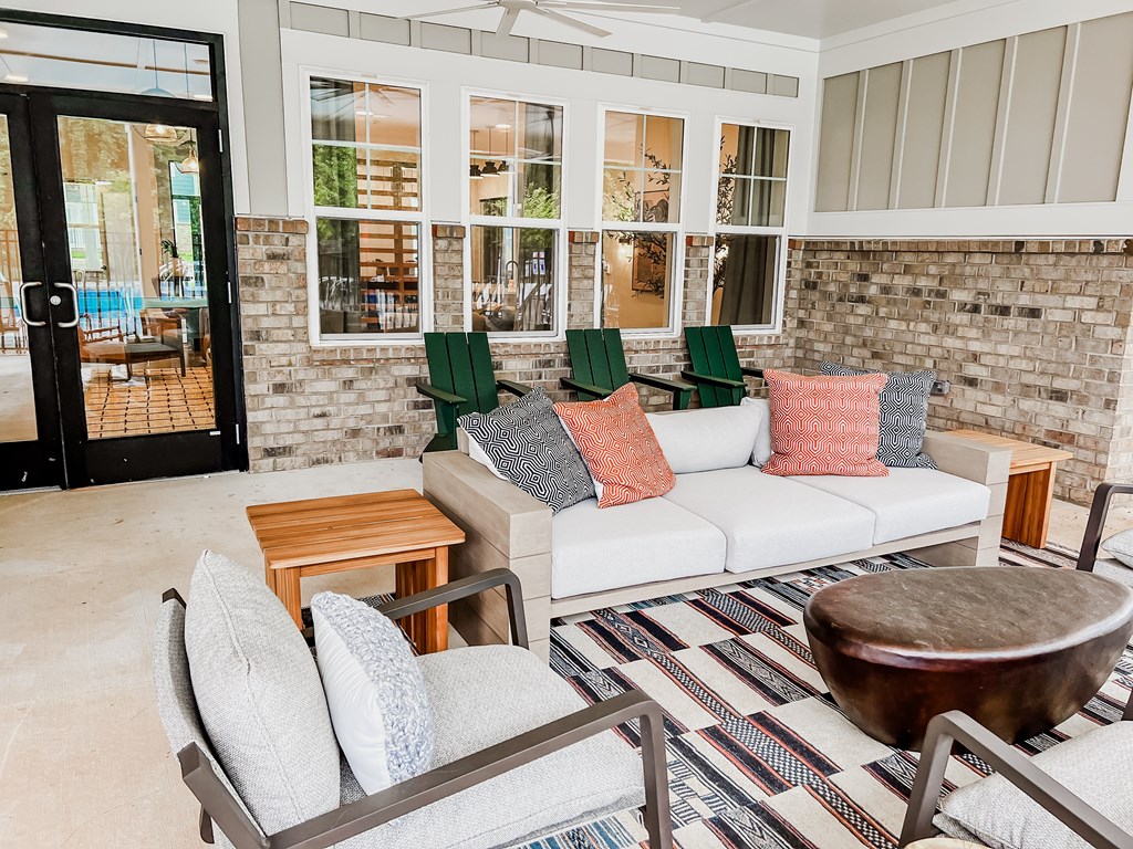 A patio with a white couch and a wooden table.