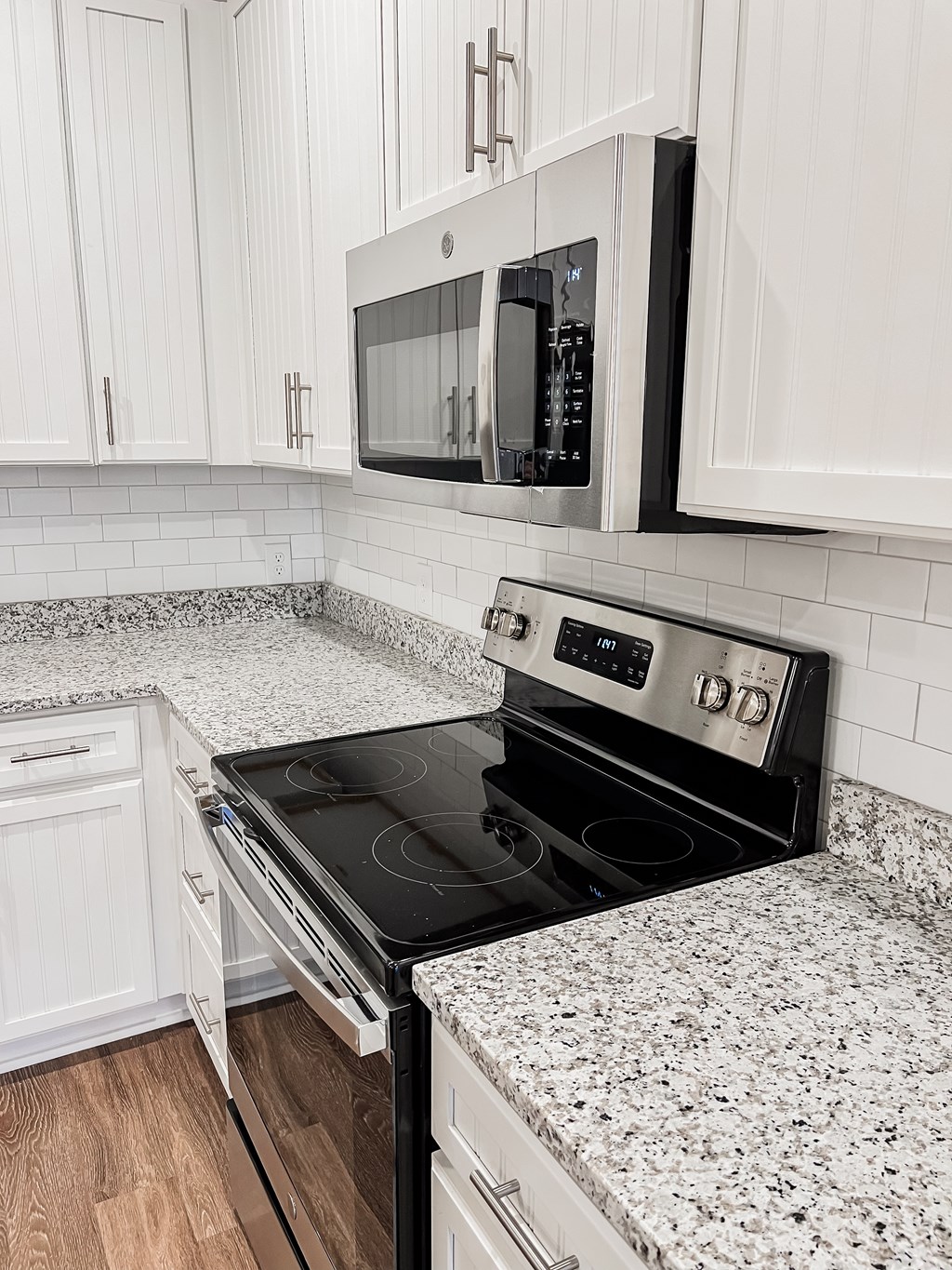 A kitchen with a black stove top oven and white cabinets.