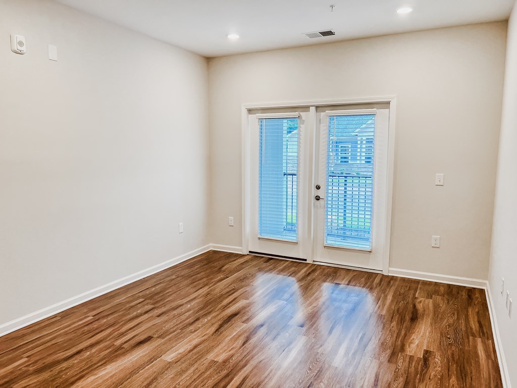 A room with a wooden floor and a sliding glass door.