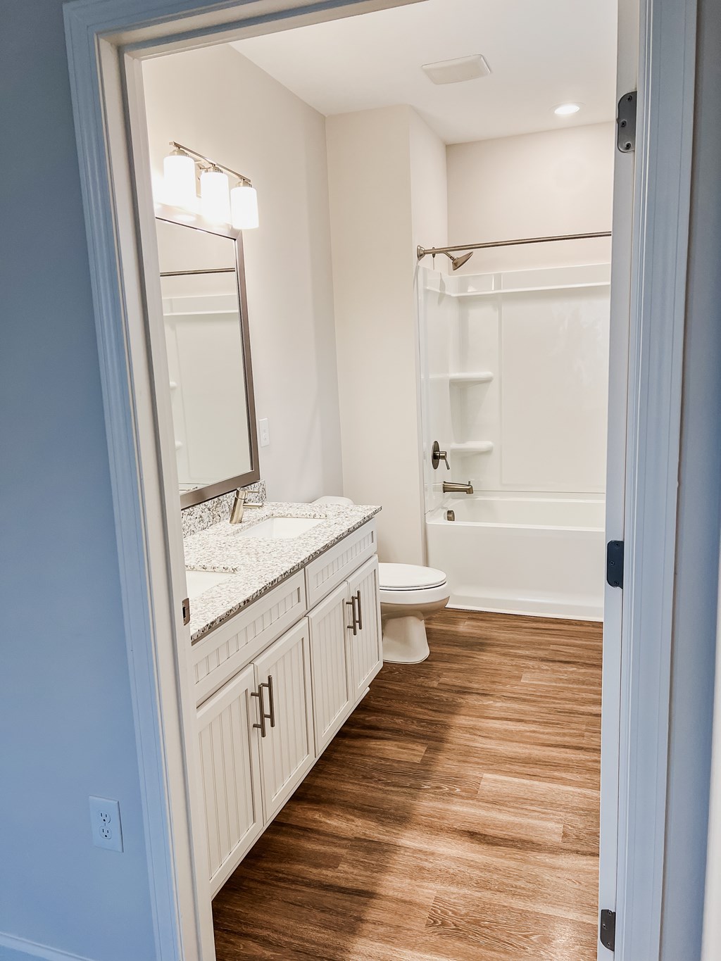 A bathroom with a toilet, sink, and mirror.