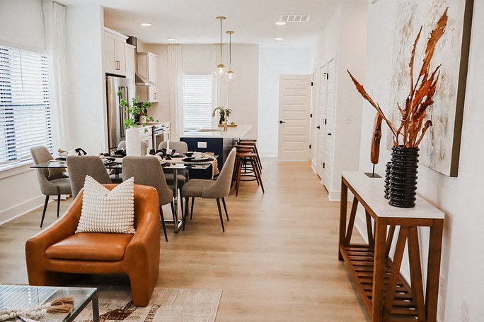 a living room and dining room with a table and chairs