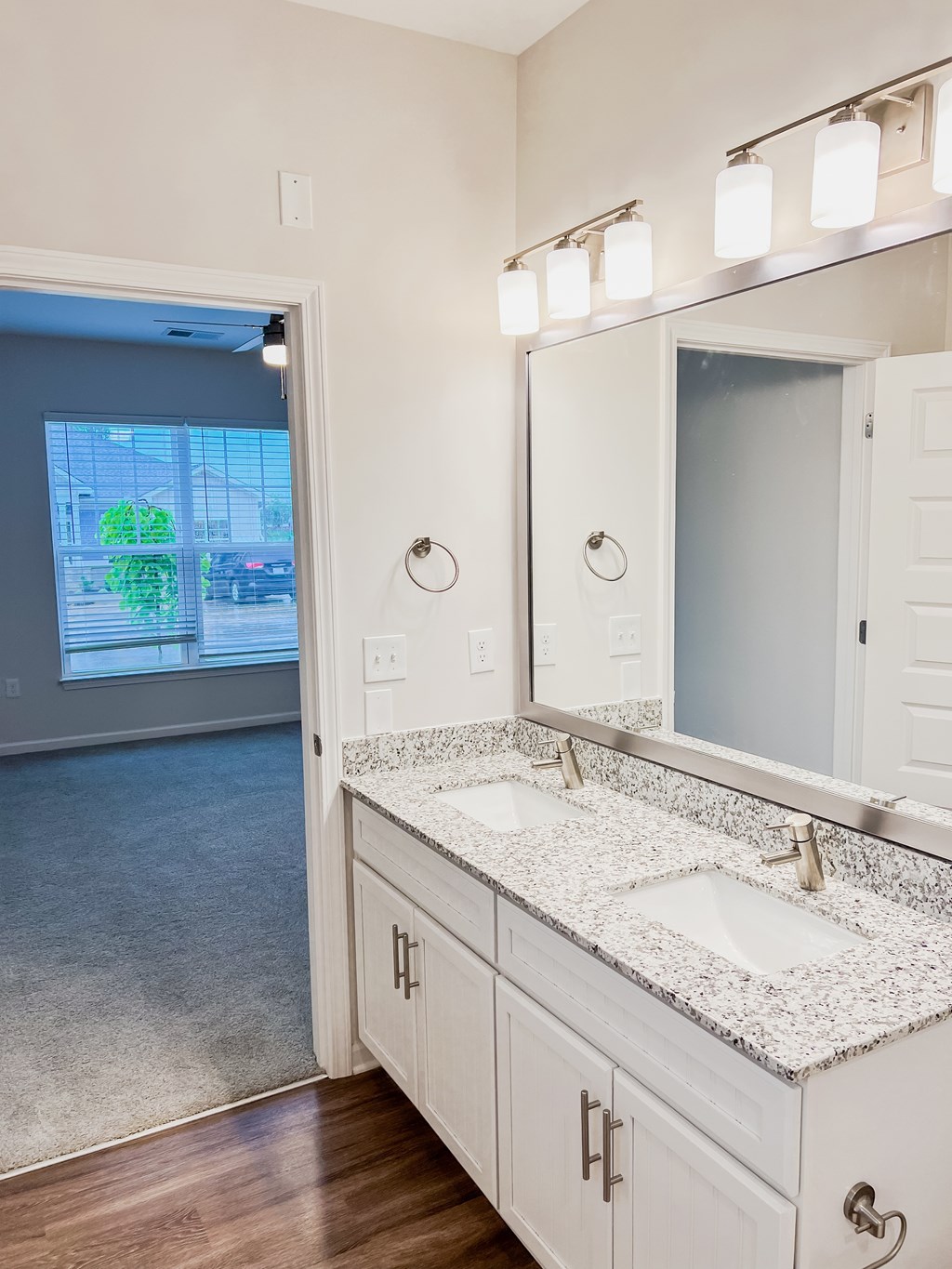 A bathroom with a large mirror and two sinks.