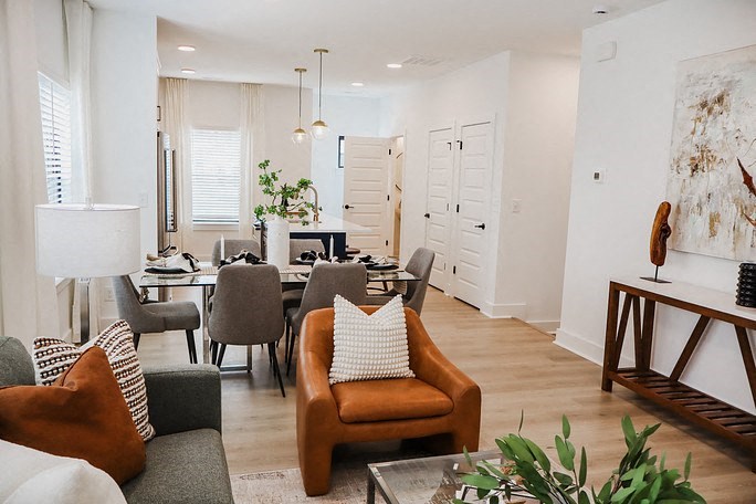 a living room and dining room with a table and chairs
