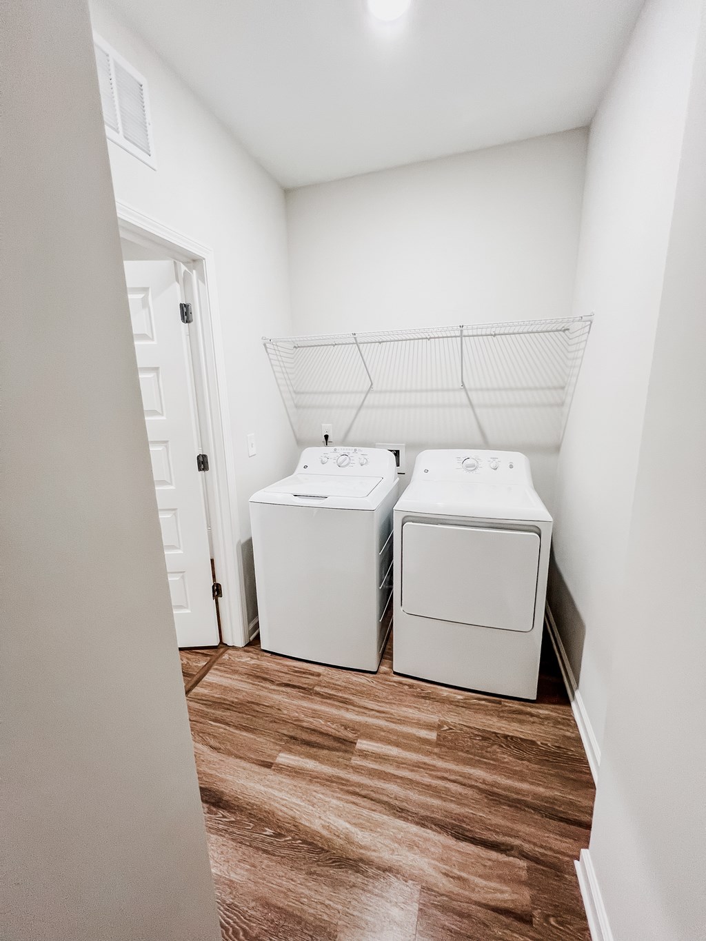A laundry room with two washing machines and a clothes dryer.