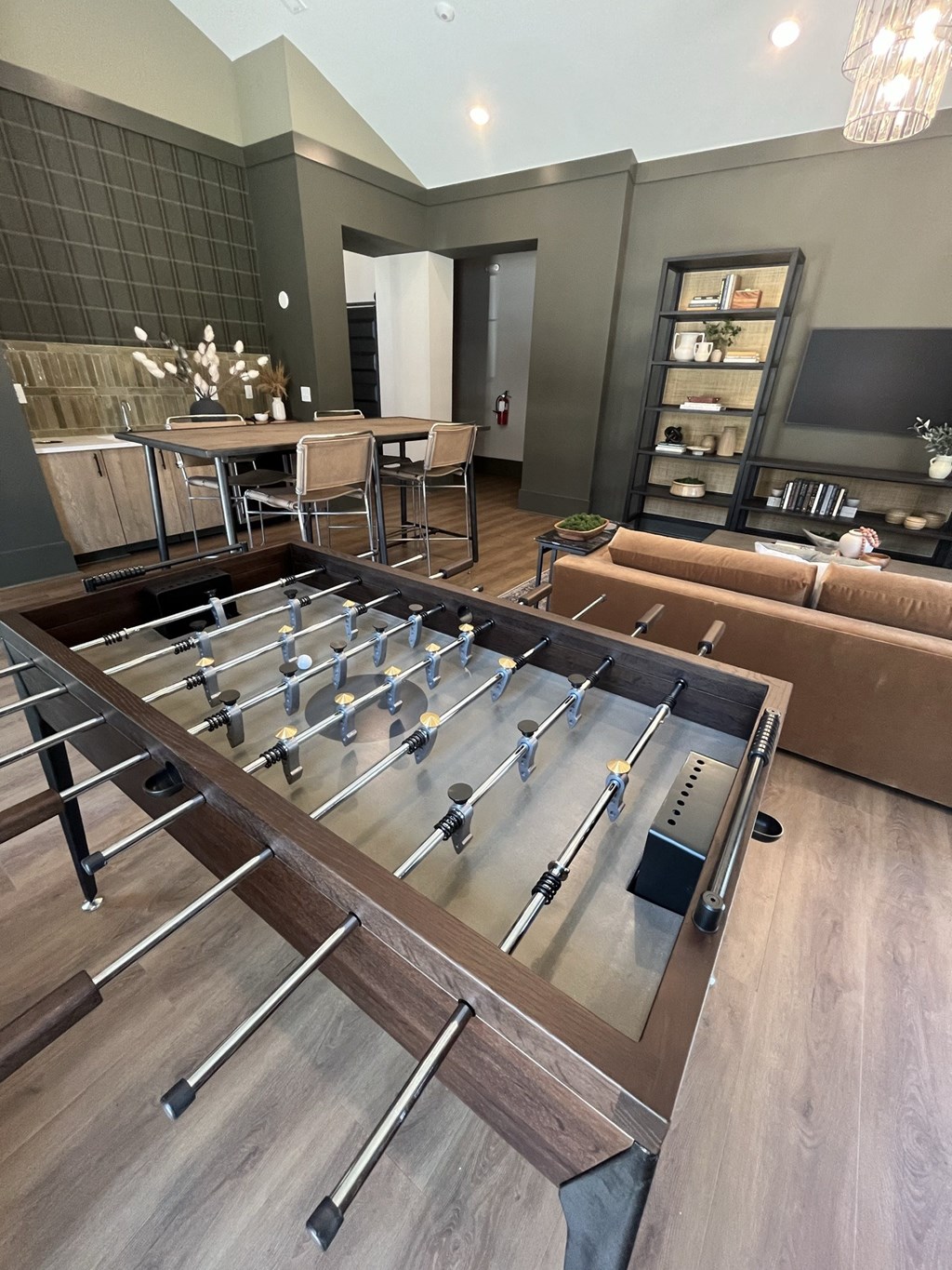 a foosball table sits in the middle of a living room at Landon Green Artisan Cottages Apartments, Hickory, NC, 28601