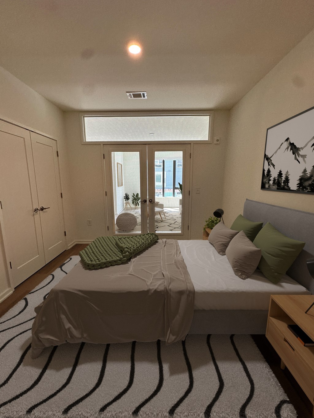 a small bedroom with a bed and a rug