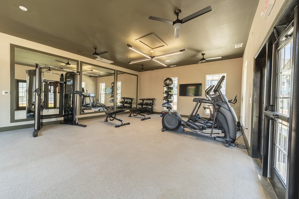 a large fitness room with exercise equipment and a large window at Landon Green Artisan Cottages Apartments, Hickory, NC