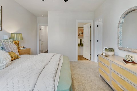 A bedroom with a large bed and a dresser.