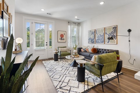 A living room with a black and white rug and a green chair.