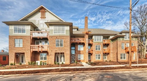 A large apartment complex with multiple balconies and a clear sky above.