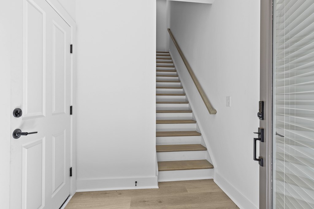 A white door is open to a staircase.